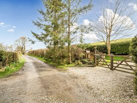 A gravel path leading to a gate with trees alongside at Converted Stone Barn -20 Acres - Farm Animals! Corwen
