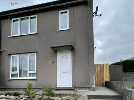 A house with a white door and windows at 2 Bed House - Sleeps 4 - Garden - Parking - Wifi in Kendal