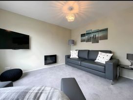 A living room with a sofa, television, and lamp at 2 Bed House - Sleeps 4 - Garden - Parking - Wifi, Kendal