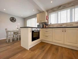 A kitchen with appliances and a dining table at 2 Bed House - Sleeps 4 - Garden - Parking - Wifi in Kendal