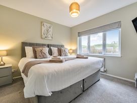 A bedroom with a large bed and windows at 2 Bed House - Sleeps 4 - Garden - Parking - Wifi in Kendal