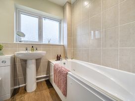 A bathroom with a bathtub and sink at 2 Bed House - Sleeps 4 - Garden - Parking - Wifi in Kendal