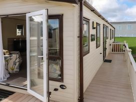 A caravan with an open door and decking at CaravanSleeps6-FreeParking-QuietRetreat-Nature in Paignton