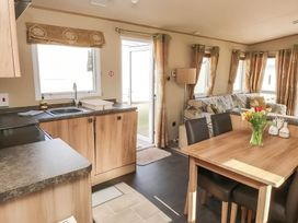 A kitchen and living room area with table and chairs at CaravanSleeps6-FreeParking-QuietRetreat-Nature in Paignton