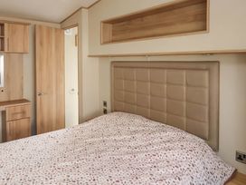 A bedroom with a bed and shelves at CaravanSleeps6-FreeParking-QuietRetreat-Nature in Paignton