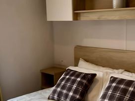 A bedroom with a bed and pillows at 293 Static caravan Beverley Bay Paignton