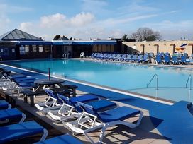 An outdoor pool area with sun loungers and a swimming pool at 293 Static caravan Beverley Bay Paignton