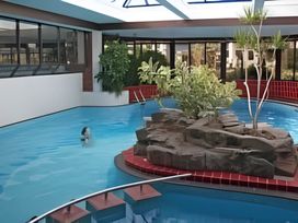 An indoor pool area with a rock formation and plants at 293 Static caravan Beverley Bay Paignton