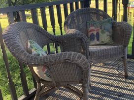 Two wicker chairs with cushions on an outdoor deck at Dobbin the horse box in The Lake District Cockermouth