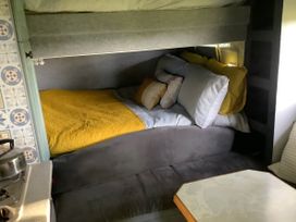 A compact sleeping area with bedding and pillows at Dobbin the horse box in The Lake District Cockermouth