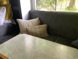 A living room with a couch and pillows at Dobbin the horse box in The Lake District