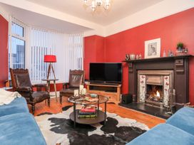 A living room with a fireplace and television at Rhiwlas in Rhosneigr