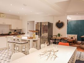 A kitchen with a table and chairs at Rhiwlas in Rhosneigr