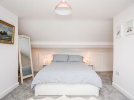 A bedroom with bed and mirror at Rhiwlas in Rhosneigr