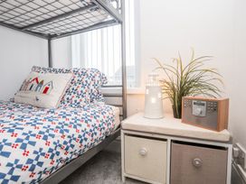A bedroom with a bunk bed and nightstand at Rhiwlas in Rhosneigr