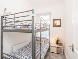 A bedroom with a bunk bed and a nightstand at Rhiwlas Rhosneigr
