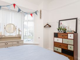 A bedroom featuring a bed and a dressing table with a mirror at Rhiwlas in Rhosneigr