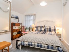 A bedroom with a bed and dresser at Rhiwlas in Rhosneigr