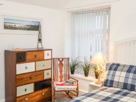 A bedroom with a bed and drawers at Rhiwlas in Rhosneigr