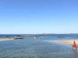 A beach with boats and islands at Rhiwlas in Rhosneigr