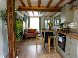 A kitchen with stools and a sofa at Cotswolds Cozy Cottage Retreat - pet friendly Finstock