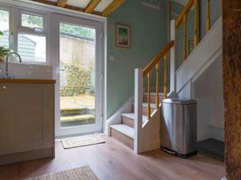 A kitchen sink and stairs in the entrance of Cotswolds Cozy Cottage Retreat - pet friendly, Finstock