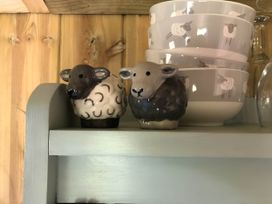 Sheep figurines and bowls on a shelf at The Shepherds Hut at Hafoty Boeth Corwen