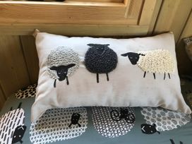 A decorative cushion with sheep designs at The Shepherds Hut at Hafoty Boeth in Corwen