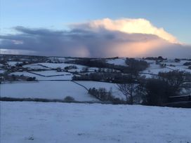 A snowy landscape with fields and trees at The Shepherds Hut at Hafoty Boeth Corwen