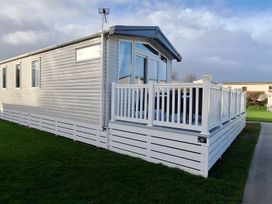 A mobile home with a deck and railing at Tranquil Lodge Retreat in Paignton