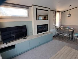 A living room with a television and fireplace at Tranquil Lodge Retreat in Paignton