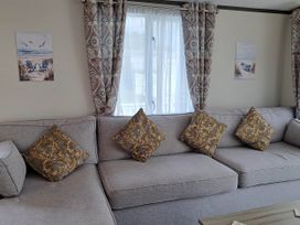 A living room with a sofa and wall art at Tranquil Lodge Retreat in Paignton