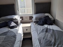 A bedroom with twin beds and a bedside table at Tranquil Lodge Retreat in Paignton