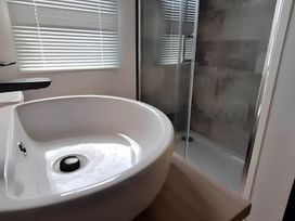 A sink and shower in a bathroom at Tranquil Lodge Retreat in Paignton