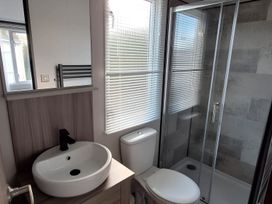 A bathroom with a sink, toilet, and shower stall at Tranquil Lodge Retreat in Paignton