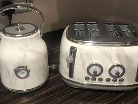 A kettle and toaster on a countertop in a kitchen