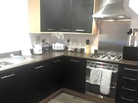 A kitchen with appliances on countertop at 2-Bed Apartment Sleeps 4 with Garden