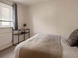 A bedroom with a bed, desk, and plant at 2-Bed Apartment Sleeps 4 with Garden