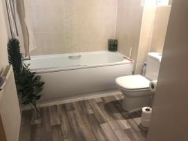 A bathroom with a bathtub and toilet at 2-Bed Apartment Sleeps 4 with Garden