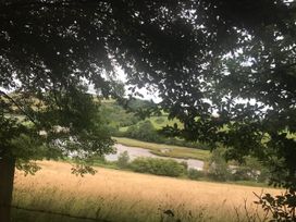 A view of a river and hills surrounded by trees and grass at 2-Bed Apartment Sleeps 4 with Garden