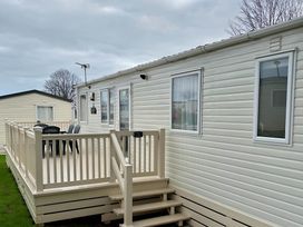 An outdoor area with a deck and chairs at Beautiful Static Caravan Hoburne Devon Bay