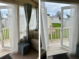 A living room with a sliding door leading to the balcony at Beautiful Static Caravan Hoburne Devon Bay