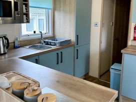 A kitchen with sink and cabinets at Beautiful Static Caravan Hoburne Devon Bay