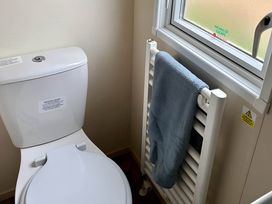 A bathroom with a toilet and a radiator at Beautiful Static Caravan Hoburne Devon Bay