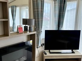 A living room with a television and lamp at Beautiful Static Caravan Hoburne Devon Bay