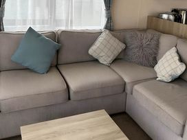 A living room with a sofa and cushions at Beautiful Static Caravan Hoburne Devon Bay