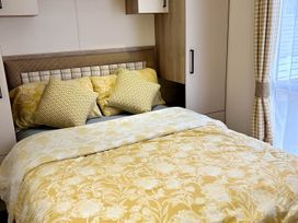 A bedroom with a bed and wardrobe at Beautiful Static Caravan Hoburne Devon Bay