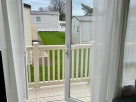 A door opening to a balcony with grass at Beautiful Static Caravan Hoburne Devon Bay