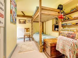 A bedroom with a bunk bed and toys on a shelf at Family Country Cottage with a private Valley View