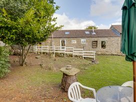 A garden view with trees and a stone building at Family Country Cottage with a private Valley View